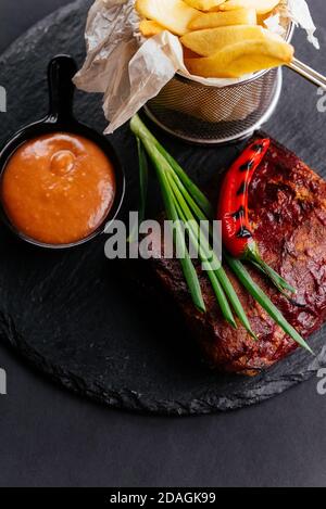 costolette di manzo alla griglia con salsa e patate Foto Stock
