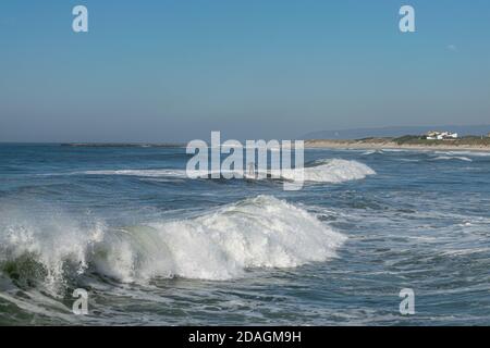 Sessione di surf a Ofir Beach in Portogallo nel mese di novembre. Surfer che cattura un'onda, l'oceano si gonfia. Sport acquatici nelle giornate fredde. Foto Stock