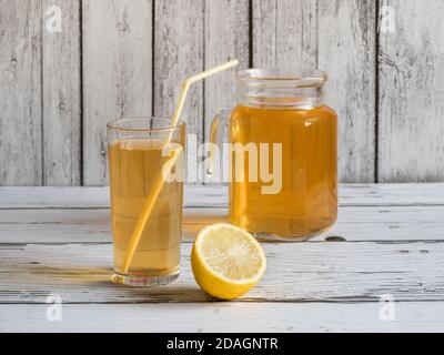 Kombucha fungo. Bevanda biologica fermentata al tè con limone su un tavolo di legno bianco. Foto Stock