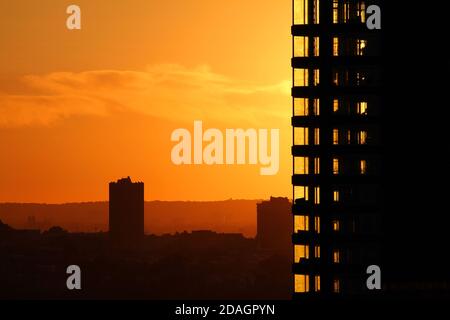 Il tramonto arancione e gli alti edifici Foto Stock