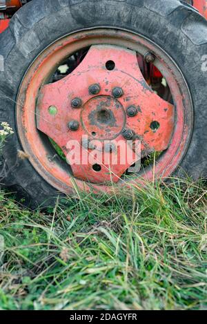 Primo piano della grande ruota motrice rossa russa sull'erba autunnale Durante raccolti stagionali in Bulgaria dettaglio rurale con affilato messa a fuoco Foto Stock