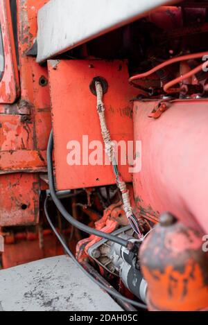 Il sistema di trattore con motore vintage fa parte della vecchia macchina pesante con motore diesel primo piano grunge olio arrugginito rosso sporco dettaglio astratto con affilato messa a fuoco selettiva Foto Stock