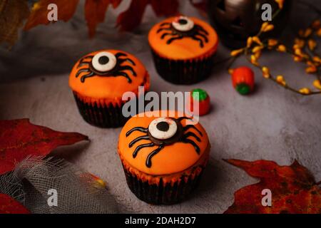 I cupcakes di Halloween Spider ricoperti di fondante arancione, fuoco selettivo Foto Stock