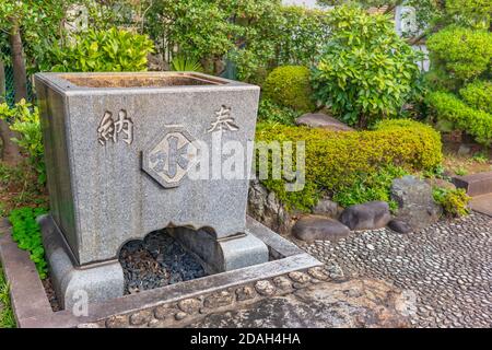 tokyo, giappone - novembre 10 2020: Pietra di abluizione dell'acqua di Shinto chiamata temizuya o chozuya usata per purificazione adornata con i kanji giapponesi di acqua Foto Stock