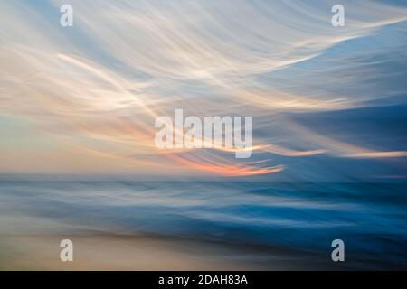 Stagcape astratto. Il movimento sfoca il tramonto tropicale della spiaggia con riflessi del sole. Sfondo creativo in blu chiaro, rosa, giallo Foto Stock