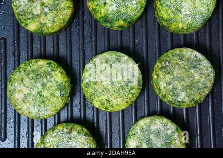 Hamburger di ceci vegano, tagliole o polpettine. Verdure spinaci verdi e cotolette di broccoli. Alimentazione vegana sana. Foto Stock