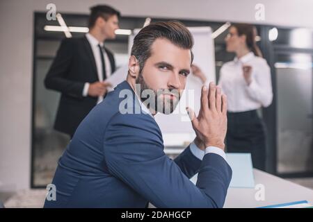 Giovane uomo sopportato seduto in ufficio dopo la presentazione Foto Stock