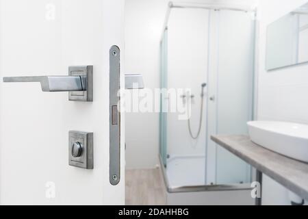 porte bianche si aprono su un bagno. Foto Stock