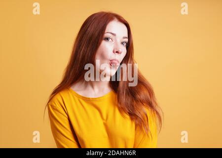 giovane donna sassosa silly cheeky che si stacca la lingua Foto Stock