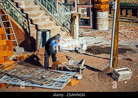 Tizi N'Tichka, Marocco - 25 DICEMBRE 2019: Muratore marocchino che lavora per lavori di ristrutturazione dell'hotel durante una giornata di sole Foto Stock