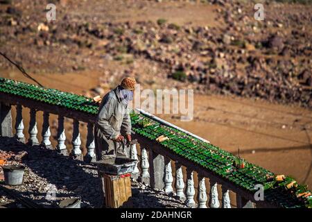 Tizi N'Tichka, Marocco - 25 DICEMBRE 2019: Muratore marocchino che lavora per lavori di ristrutturazione dell'hotel durante una giornata di sole Foto Stock