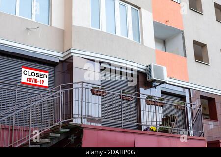 Primo piano su un cartello rosso chiuso nella finestra di Un negozio che visualizza il messaggio chiuso a causa di Covid-19 Foto Stock