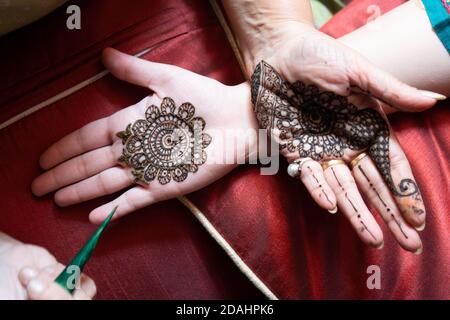 Top down video di una donna che copia il tatuaggio mehndi henné da una parte all'altra in preparazione della festa indù di teej, karwachauth, diwali Foto Stock