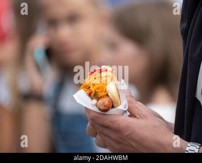 Crop uomo con hot dog in folla Foto Stock