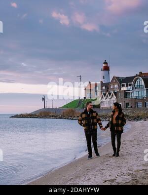 Urk Flevoland Holland, coppia di uomini e donne che guardano il tramonto al Piccolo villaggio di pescatori porto di Urk Paesi Bassi Foto Stock