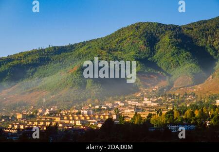 Vista panoramica della valle di Thimphu con montagne boscose colline e case a Thimphu, capitale del Bhutan alla luce del tardo pomeriggio Foto Stock