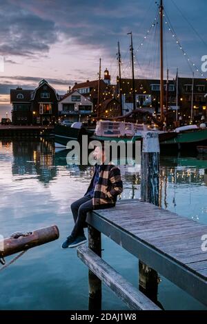 Urk Flevoland Holland, coppia di uomini e donne che guardano il tramonto al Piccolo villaggio di pescatori porto di Urk Paesi Bassi Foto Stock