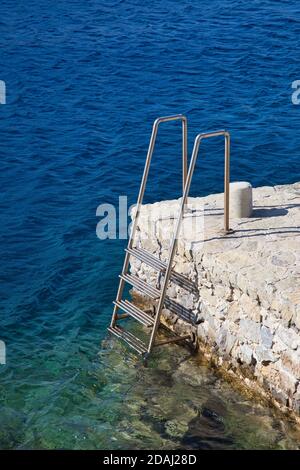 Scalinata verticale che scende verso il mare nell'isola di Symi, in Grecia Foto Stock