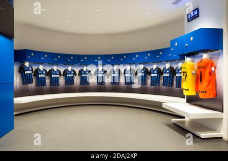 Posti a sedere per una squadra di giocatori di calcio con una divisa blu sulla parte superiore nel spogliatoio presso lo stadio Giuseppe Meazza o San Siro, buil Foto Stock