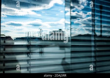 La gente che pedalerà lungo il sentiero del Tamigi verso la stazione di energia di Battersea si riflette nella finestra di un ufficio. Foto Stock