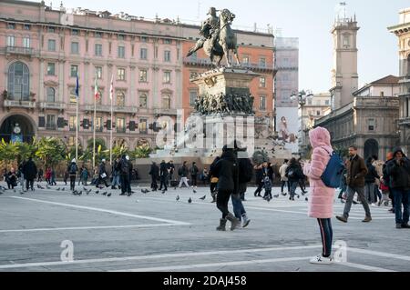 Si cammina sulla piazza principale della città di Milano - Piazza del Duomo vicino al monumento al primo re d'Italia Vittorio Emanuele II (1820-1878). Foto Stock