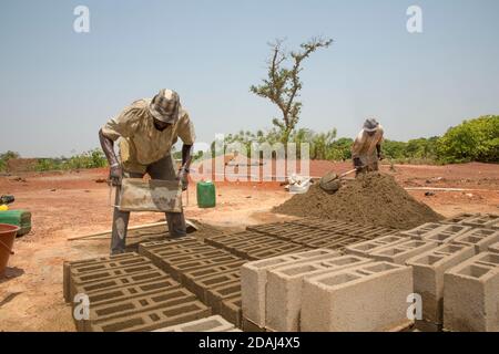 Selingue, Mali, 25 aprile 2015; muratori in cemento Moise Diarrra, (a sinistra) e Abdoulaye Togola. Foto Stock