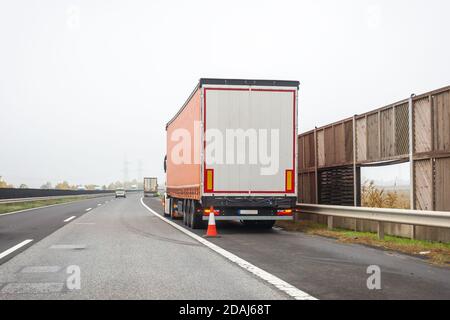 Carrello guasto sulla corsia di arresto di emergenza sul lato della strada. Problema con il veicolo in autostrada. Concetto di trasporto industriale, esportazione, importazione, logistica Foto Stock