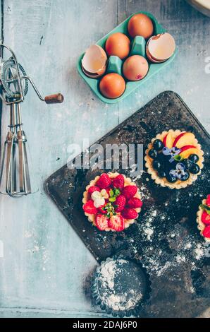 Vista dall'alto di uova, farina e diversi tipi di frutta Foto Stock