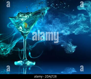 cocktail martini con spruzzi su sfondo fumoso blu scuro Foto Stock