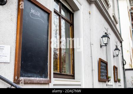 Friburgo, Germania. 13 Nov 2020. Una tavoletta di ardesia altrimenti vuota sulla parete esterna di un ristorante porta l'iscrizione 'oggi'. A causa delle restrizioni decise dai governi federali e statali, attualmente non è consentito l'apertura di ristoranti e strutture di ristorazione. Credit: Philippe von Ditfurth/dpa/Alamy Live News Foto Stock