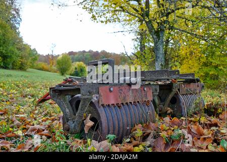 Vecchio dispositivo agricolo arrugginito a forma di rullo di campo. Foto Stock