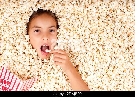 bambina sepolta in popcorn Foto Stock