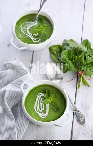 Zuppa di purea di spinaci condita con crema e menta Foto Stock