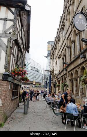 Guardando verso il Cathedral Gates nel centro di Manchester, passate i pub Mitre e Old Wellington e i ristoranti all'aperto verso il negozio Selfridges & Co. Foto Stock