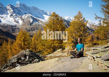 Paesaggio panoramico dell'uomo meditando sulle montagne. Parco Nazionale del Gran Paradiso. Italia Foto Stock