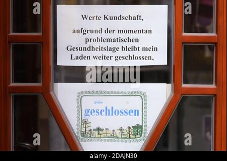 13 novembre 2020, Sassonia, Görlitz: Un cartello all'ingresso di un negozio di articoli da regalo informa i clienti circa la chiusura temporanea: 'Egregi clienti, a causa dell'attuale problematica situazione sanitaria, il mio negozio rimarrà chiuso, purtroppo chiuso. Foto: Sebastian Kahnert/dpa-Zentralbild/dpa Foto Stock