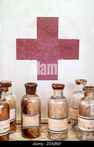 Vecchi flaconi di farmacia di fronte a un armadio di medicina Foto Stock