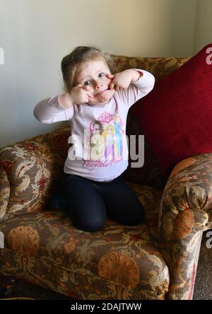 Carino bambino ragazza toddler tirando un viso divertente Foto Stock