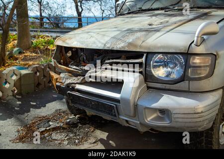 C'è una jeep bruciata nel parcheggio della strada vicino al mare. Foto Stock