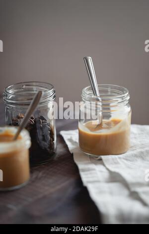 Dessert al budino di yogurt al gusto di caffè in vasetto di vetro su tavolo di legno. Stile di vita sano, supercibo Foto Stock