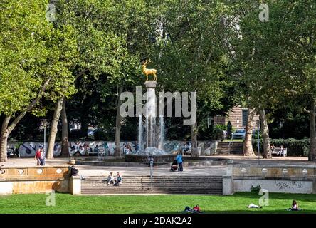 Persone che si rilassano sull'erba vicino Golden Stag, 8.8 metri colonna araldica animale di Schöneberg, scultore August Gallia, Rudolph-Wilde parco Berlino-Schöneberg, Foto Stock