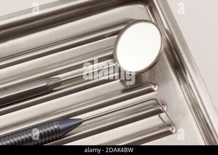 Gli strumenti odontoiatrici si trovano nel vassoio medico isolato su sfondo bianco. Foto Stock