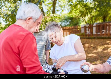 Gruppo senior in pensione o in vacanza giocando bocce in il giardino Foto Stock