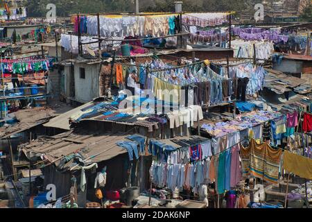 Si sta facendo una grande quantità di bucato, con gran parte di esso appeso ad asciugare su scaffali, nel centro di Mumbai, India Foto Stock