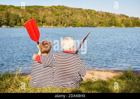 La coppia anziana felice si rilassa guardando il lago con i remi dalla barca a remi Foto Stock