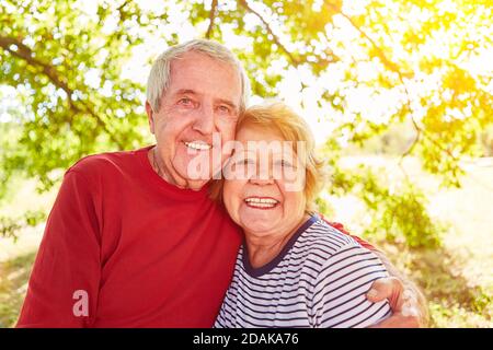 Felice coppia di anziani in abbraccio nella natura in estate Foto Stock
