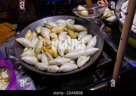 Le polpette di pesce vengono fritte con olio caldo su un piano cottura in padella. Il cibo di strada tailandese è facile e conveniente. Foto Stock