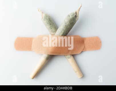 Lo stipite di cannabis è incollato con intonaco appiccicoso su una parete bianca. Foto Stock