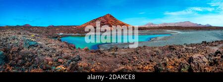 Montagna rossa e pozze verde vicino alla costa del mare in Isole Canarie, Lanzarote.Spain spiagge. Natura vulcanica impressionante e scenografica unica a Timanfaya. Foto Stock