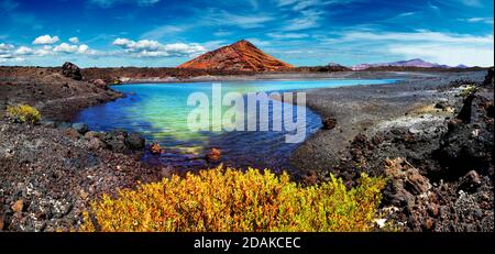 Montagna rossa e pozze verde vicino alla costa del mare in Isole Canarie, Lanzarote.Spain spiagge. Natura vulcanica impressionante e scenografica unica a Timanfaya. Foto Stock